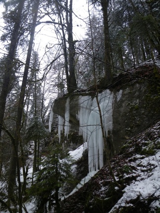 Bec rocheux. Au dessus, un arbre perché. En dessous, stalactites de glace.